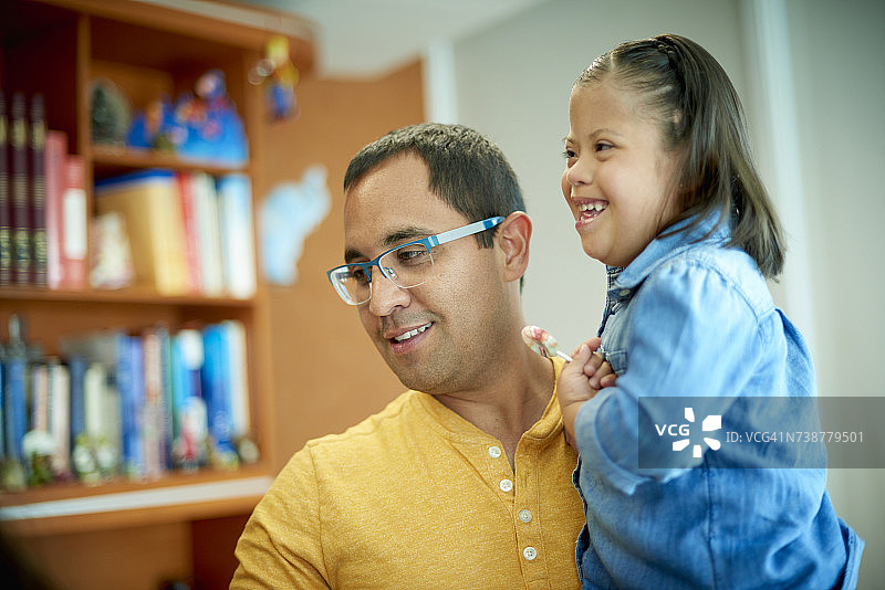 西班牙裔父亲抱着患有唐氏综合症的女儿图片素材