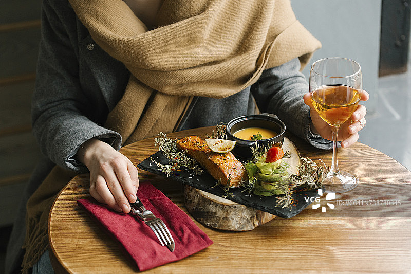 女人吃鱼，配白葡萄酒图片素材