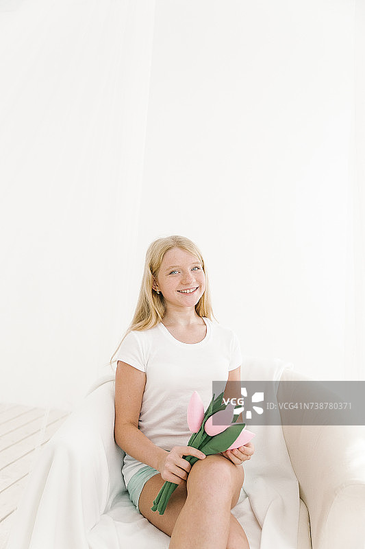 手捧玩具花朵的微笑的中东女孩肖像图片素材