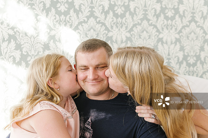 中东女儿亲吻父亲的脸颊图片素材