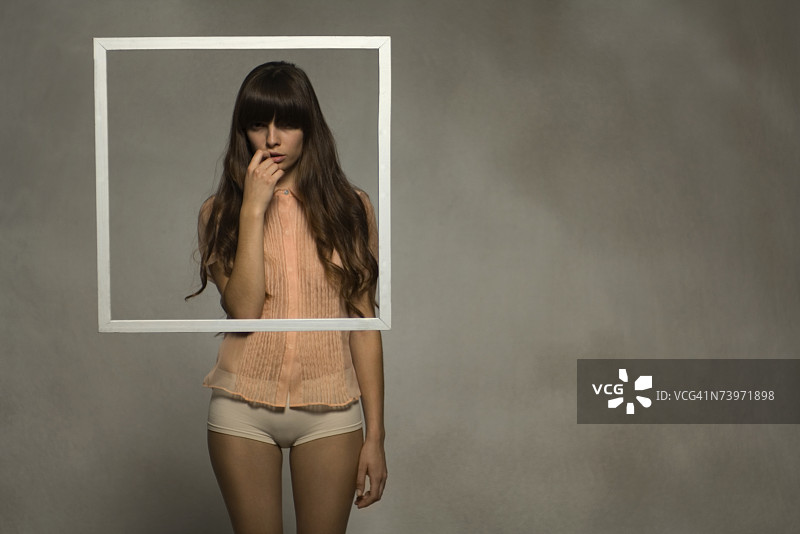 女人穿着衬衫站在水下，身前漂浮着画框图片素材