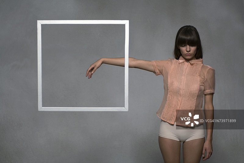 身穿衬衫站在水中的女子，手臂伸出，画框漂浮在手前图片素材