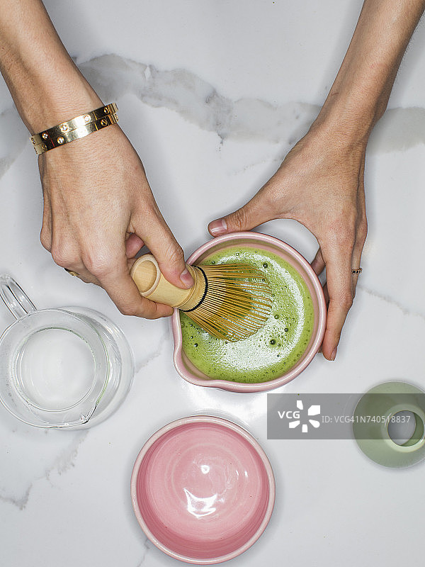用搅拌器准备抹茶绿茶的人图片素材
