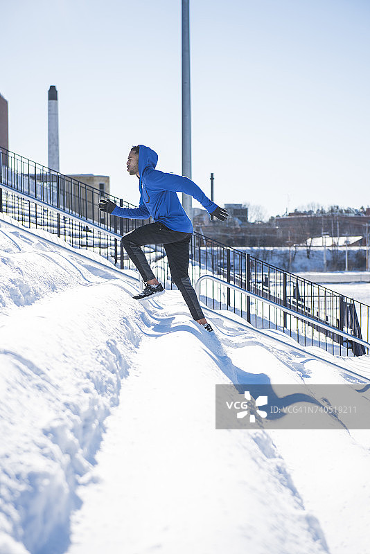 男人在雪地体育场长椅上跑步图片素材