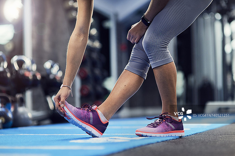 年轻女子在健身垫上触碰脚趾（腰部以下视角）图片素材