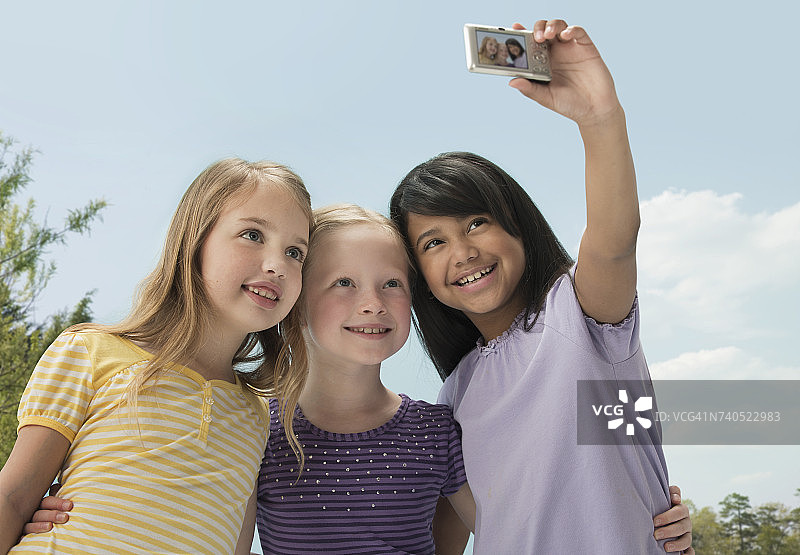 对着手机自拍的微笑女孩图片素材