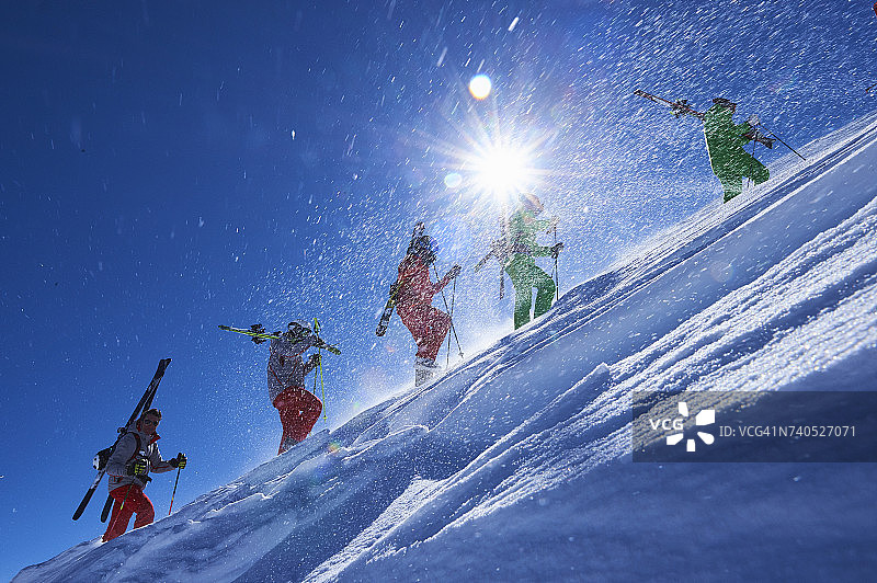 五名滑雪者在阳光明媚的陡峭山坡上跋涉，美国科罗拉多州阿斯彭图片素材