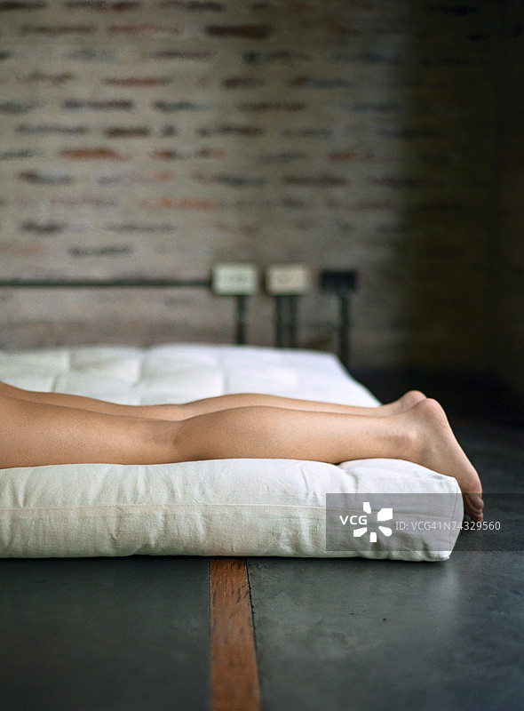 女人躺在榻榻米上，双腿伸直图片素材