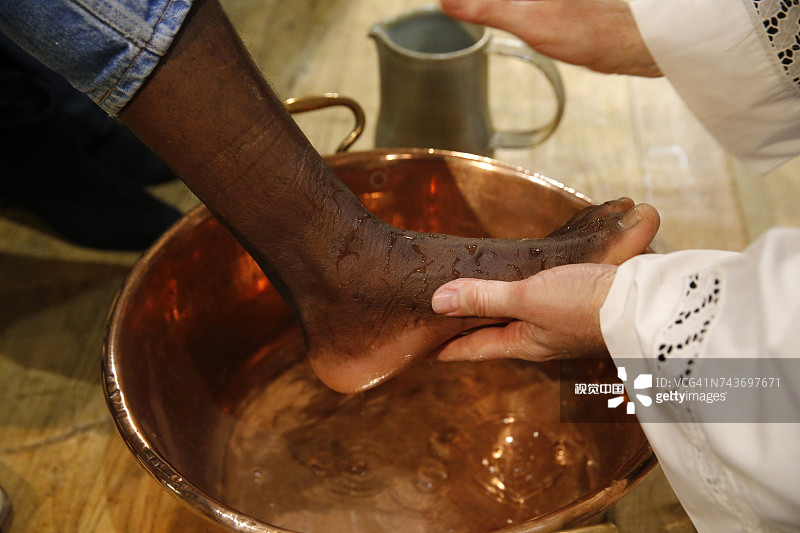 巴黎天主教堂的濯足节庆祝活动。牧师为信徒洗脚，法国。图片素材