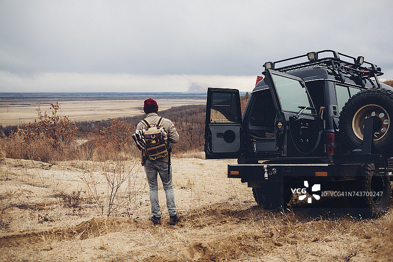 徒步者站在运动型多用途车旁，背景是俄罗斯阿穆尔的天空图片素材