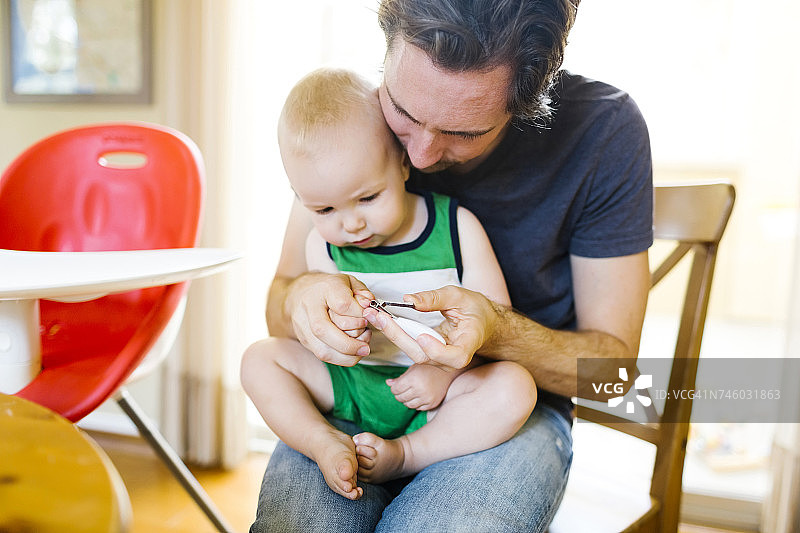 父亲给儿子（12-17个月）剪指甲图片素材