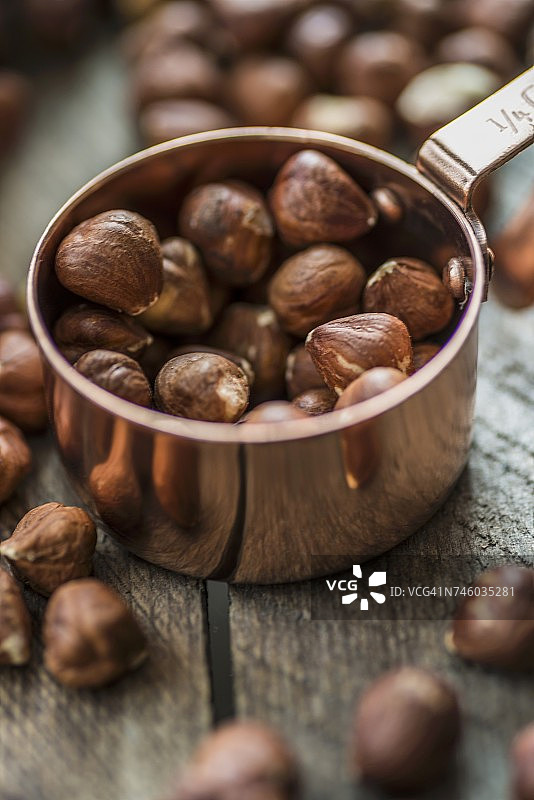 铜杯木质表面榛子图片素材