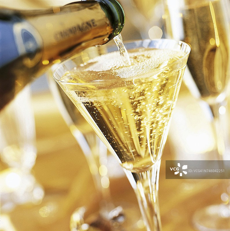香槟酒瓶倾倒，满杯香槟图片素材