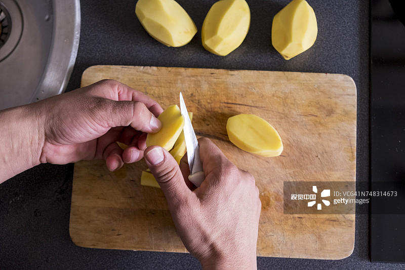 白人的手在砧板上切土豆图片素材