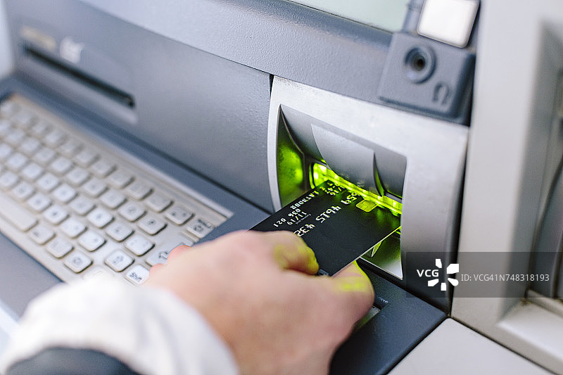 女人将信用卡插入自动取款机的特写图片素材