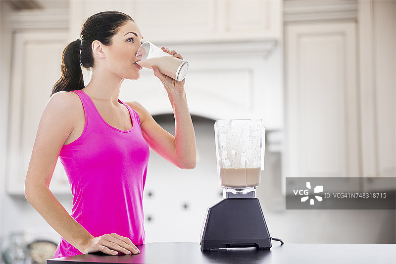 白人女性在厨房喝冰沙图片素材