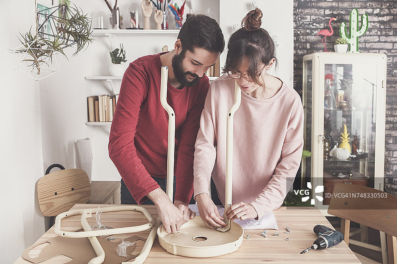 年轻夫妇在家组装平板凳图片素材