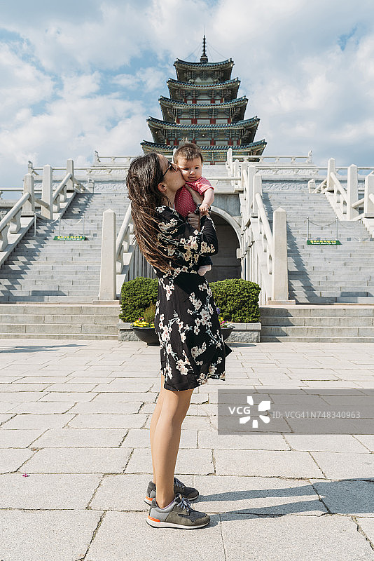 韩国首尔，女子在景福宫内的国立民俗博物馆前抱着亲吻女婴图片素材