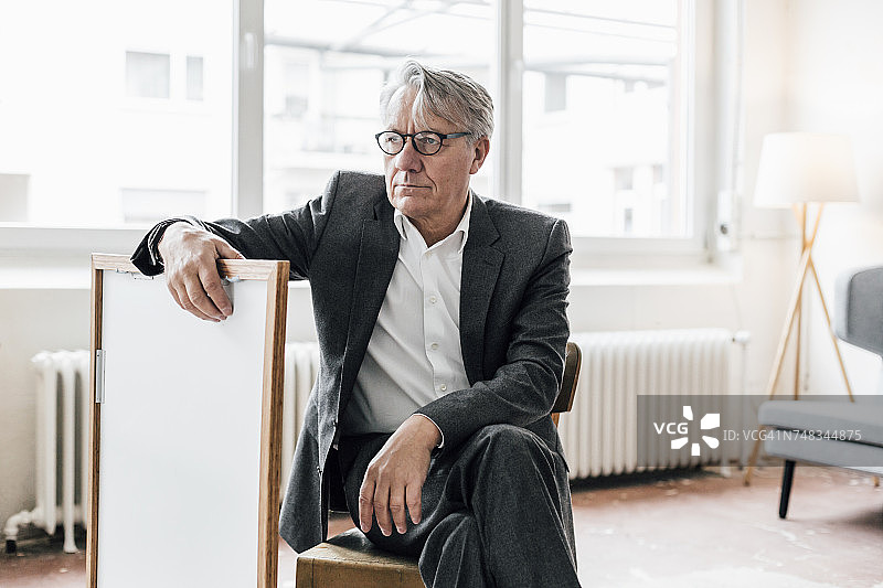 坐在带相框椅子上的年长商人图片素材