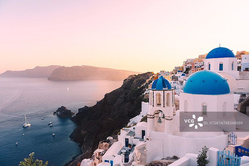 希腊圣托里尼伊亚日落时分：火山口和希腊东正教教堂景观图片素材