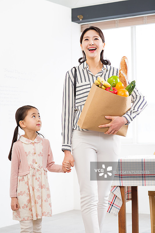 妈妈拿着菜篮和女儿一起走路图片素材