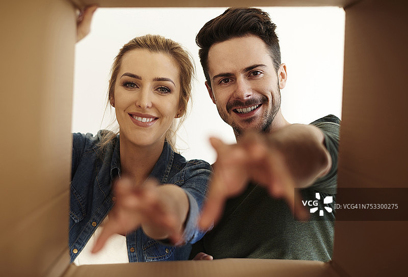 年轻夫妇伸手拿着纸箱（波兰德比察）图片素材