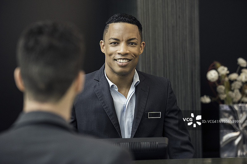 站在银行柜员柜台后面的男人图片素材