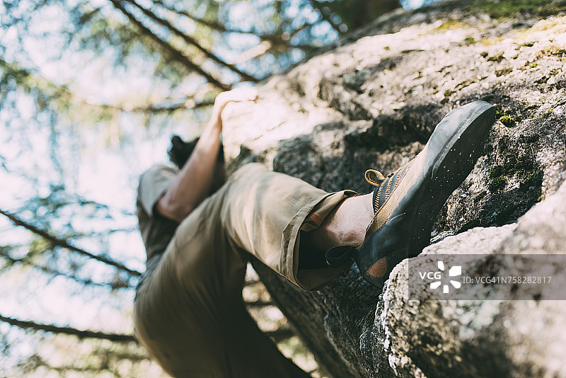 意大利伦巴第男攀岩者攀登巨石仰视图图片素材