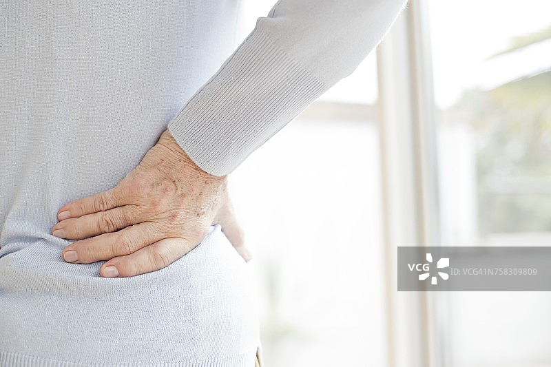 年长妇女揉痛的背部图片素材