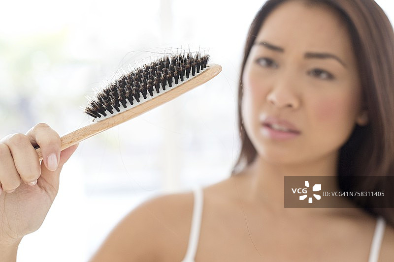 表情焦虑的女人拿着发刷图片素材