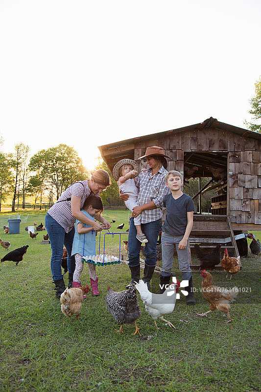 农场里一家人与鸡，母女拿着鸡蛋。图片素材