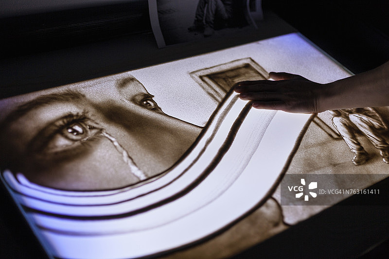 男人擦去沙滩上哭泣女人的画像，意大利撒丁岛卡利亚里图片素材