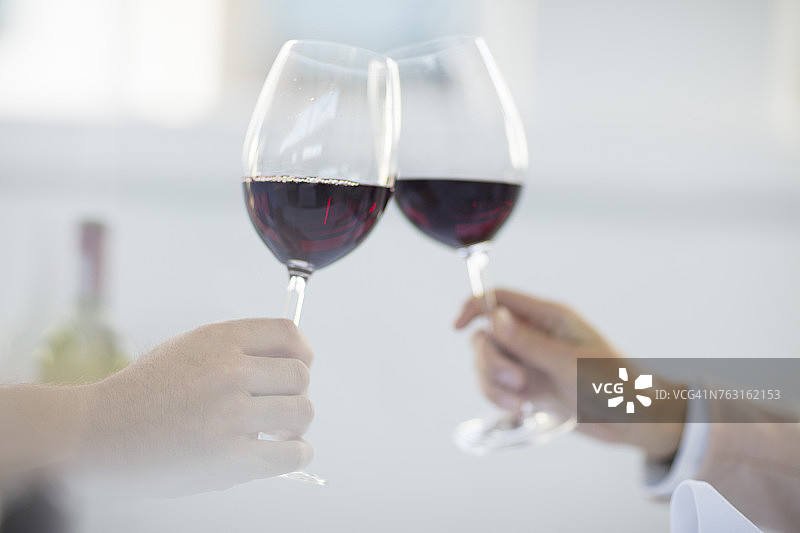 餐厅里的用餐者举着酒杯敬酒特写图片素材