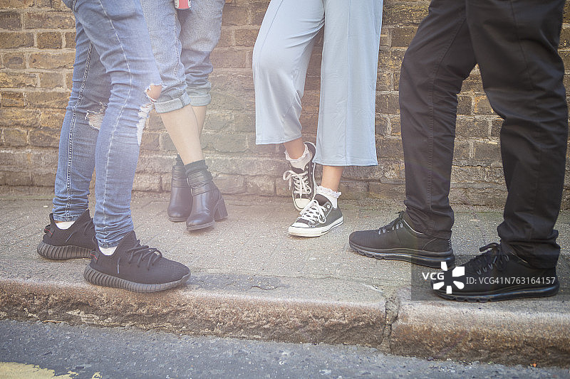 四个朋友站在街上，低角度拍摄图片素材