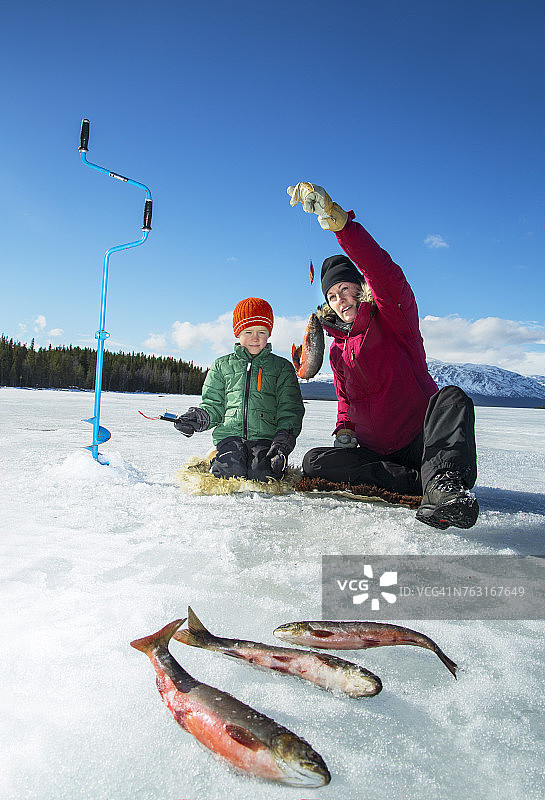 母亲和儿子冰上钓鱼图片素材