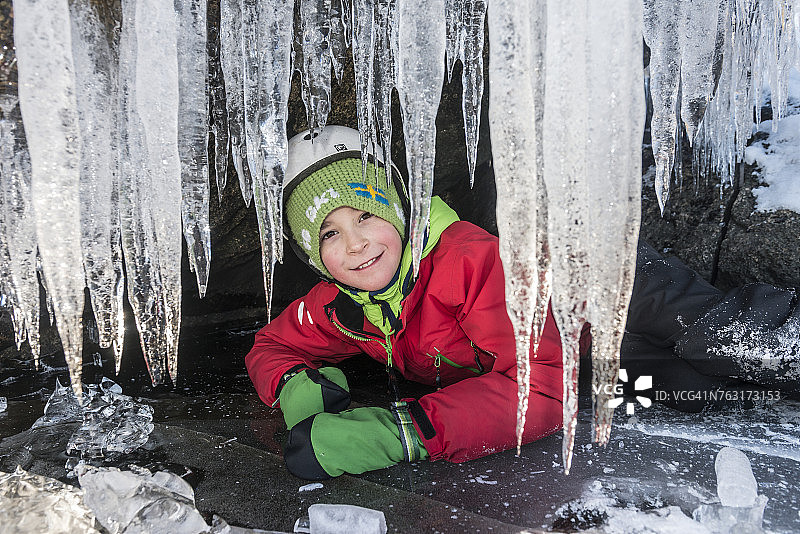 男孩藏在冰洞里图片素材