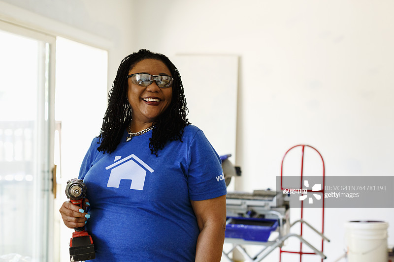 拿着电钻的黑人志愿者女性图片素材
