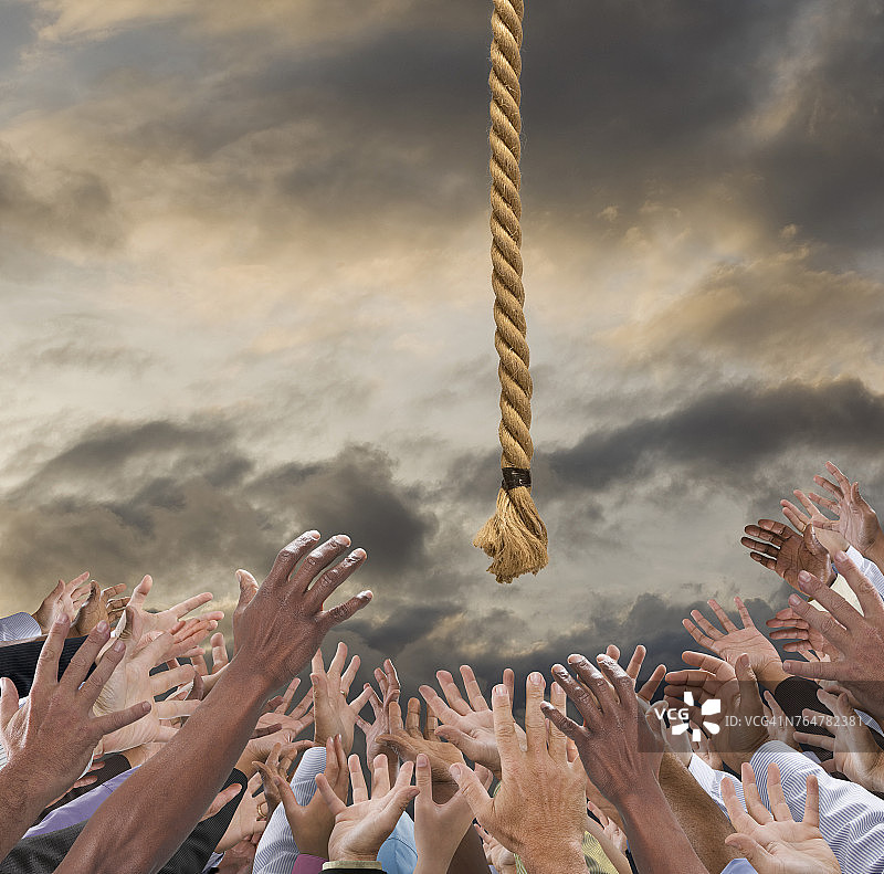 人群伸手去抓多云天空中的绳索图片素材