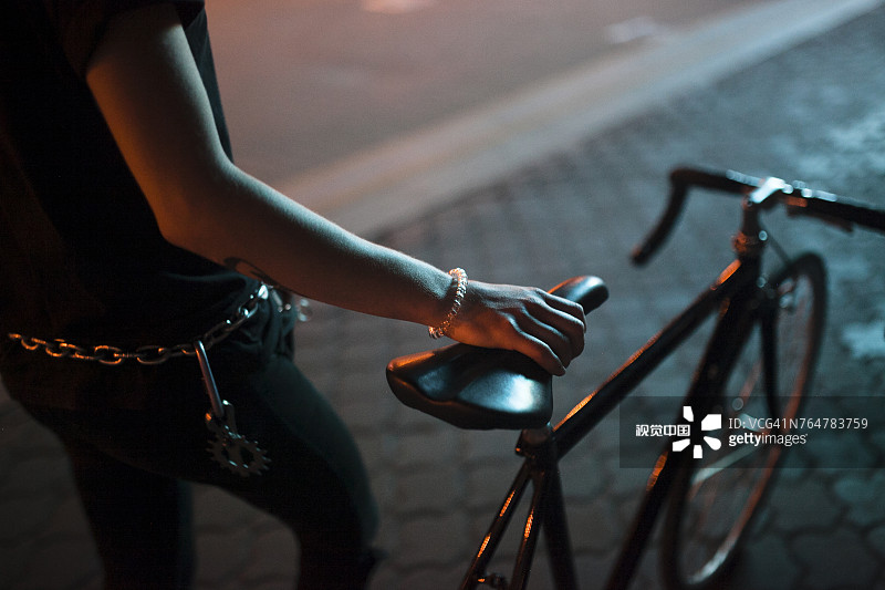 夜晚，白人男子手持自行车座图片素材