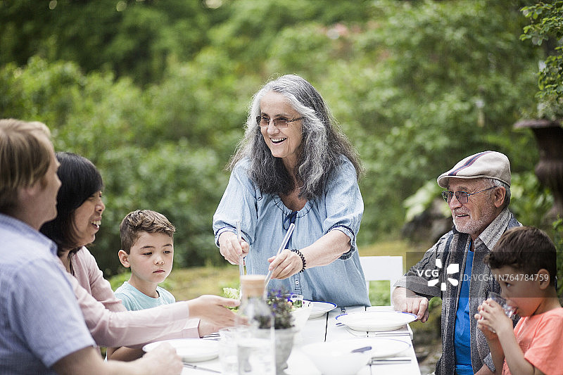 在后院餐桌旁的几代同堂家庭图片素材