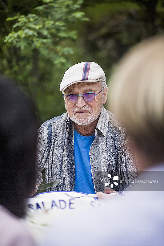 中年夫妇坐在后院一位年长男子面前图片素材