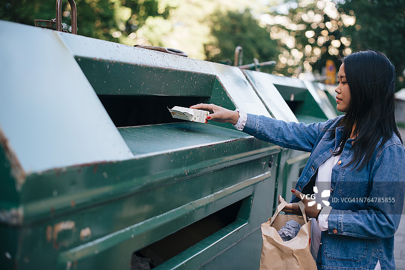 少女将包装袋扔进垃圾桶图片素材