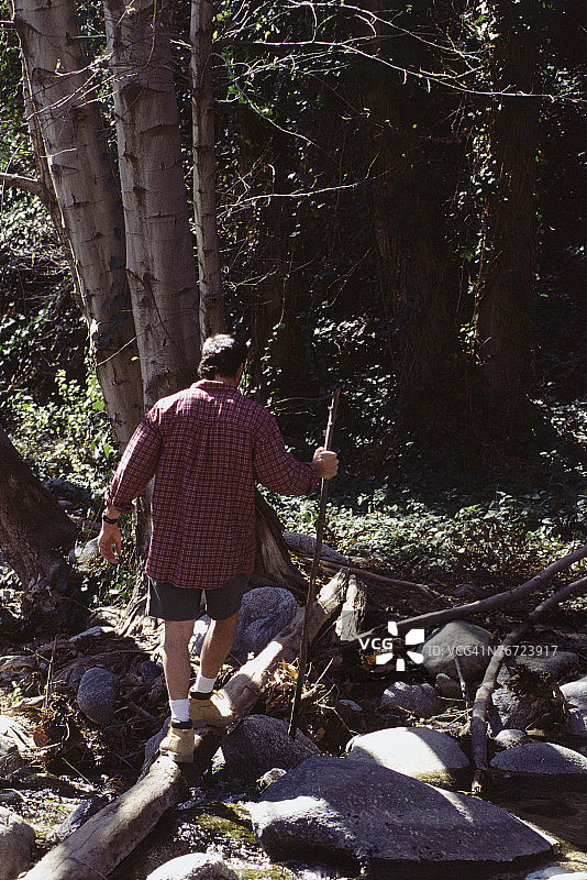 男人走在木头上图片素材