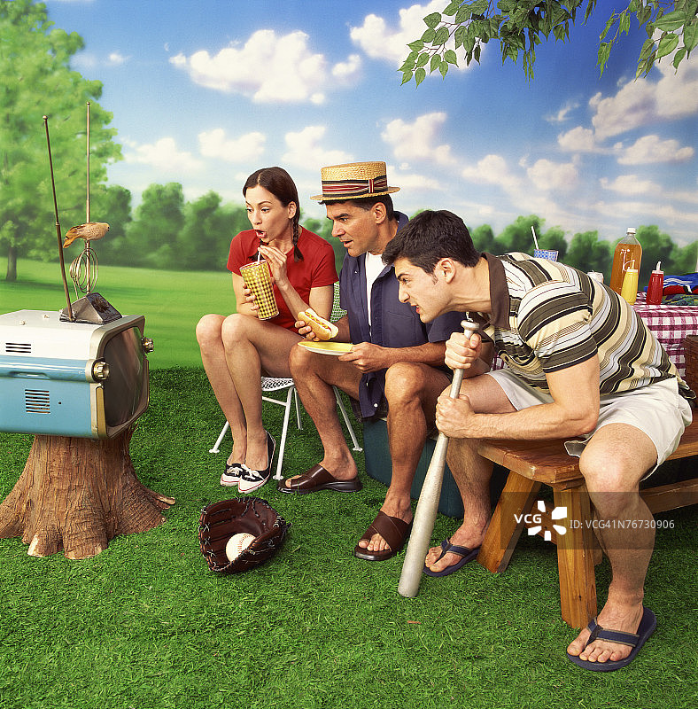 人们在野餐时看便携式电视图片素材