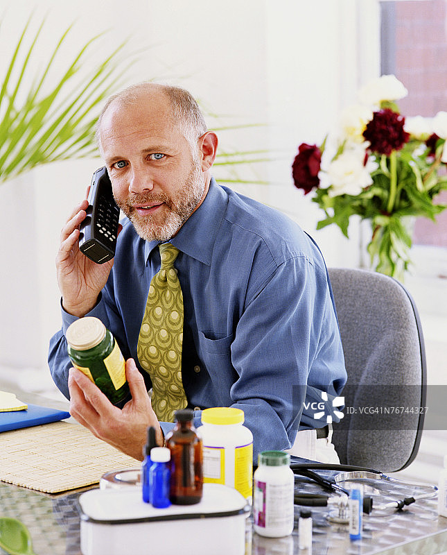 拿药和电话的男人图片素材