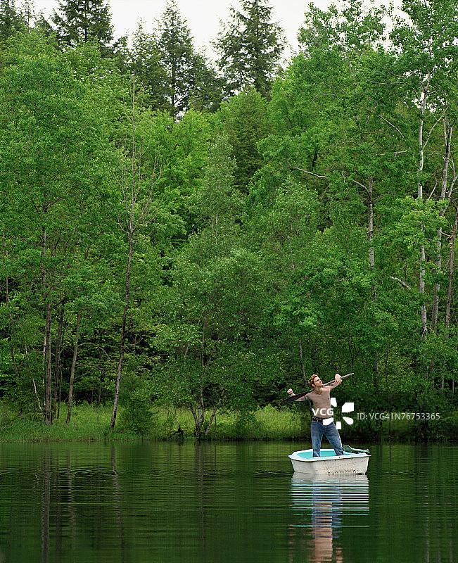 男子站在划艇上图片素材