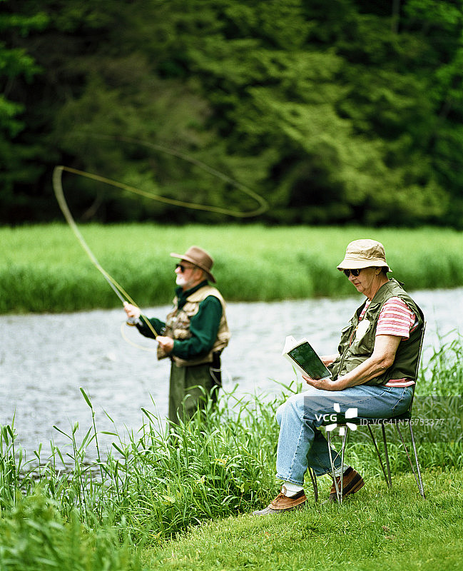 男子飞蝇钓鱼，女子读书图片素材
