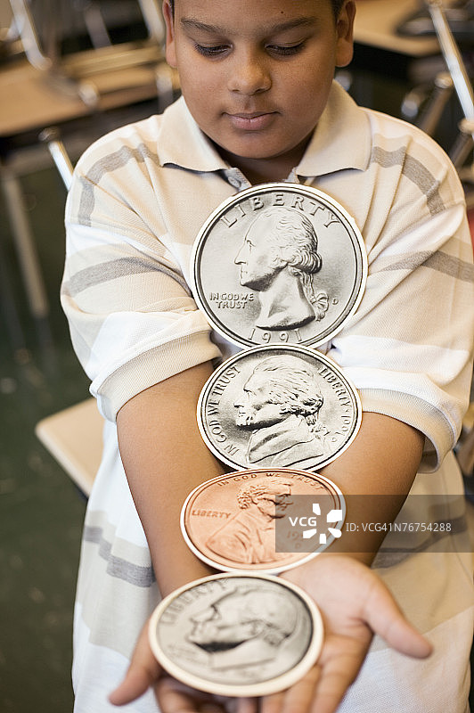 男孩拿着巨大的硬币图片素材