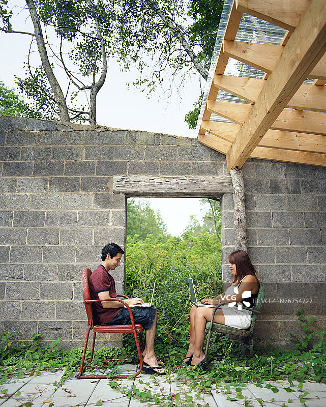 在开放式棚屋里使用笔记本电脑的夫妇图片素材