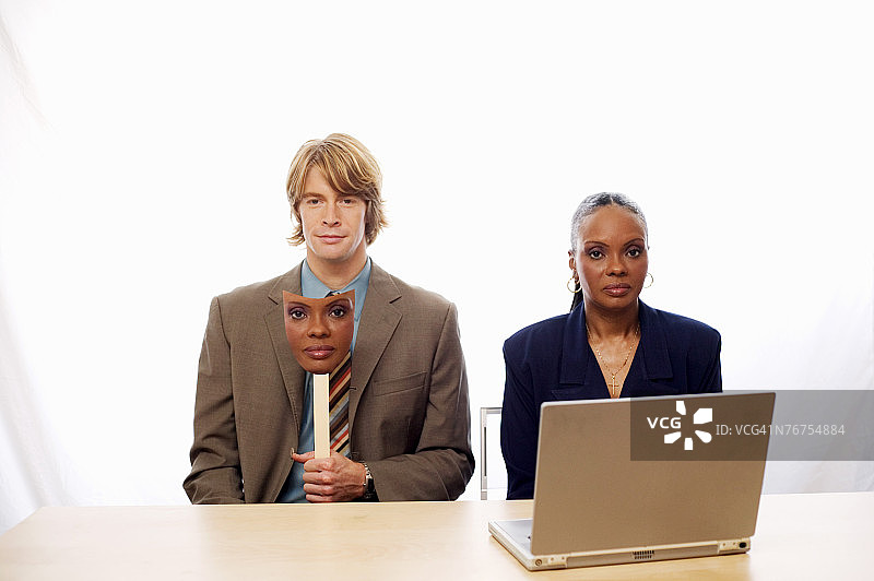 戴着女人面具和笔记本电脑的男人图片素材